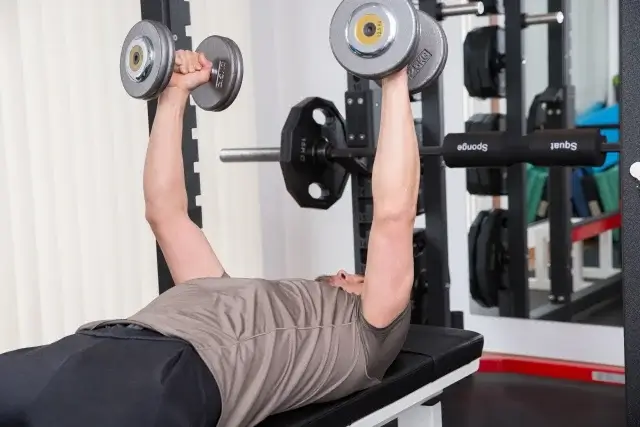 ダンベルフライのセットをしている男性
