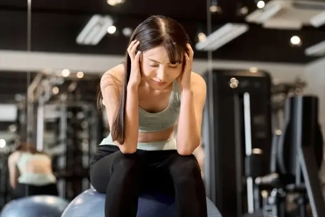 ジムで頭を抱え込む女性