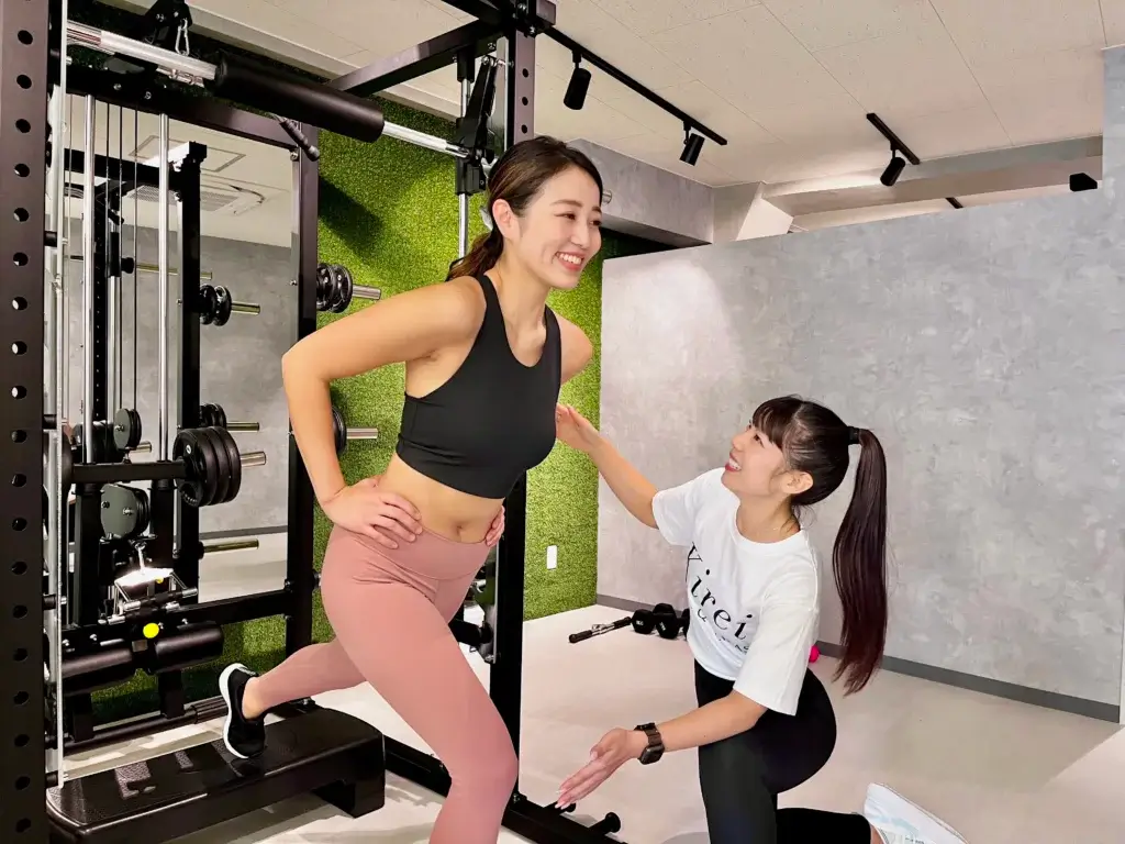 Kirei早稲田店で女性トレーナーにトレーニング指導を受けている日本人女性