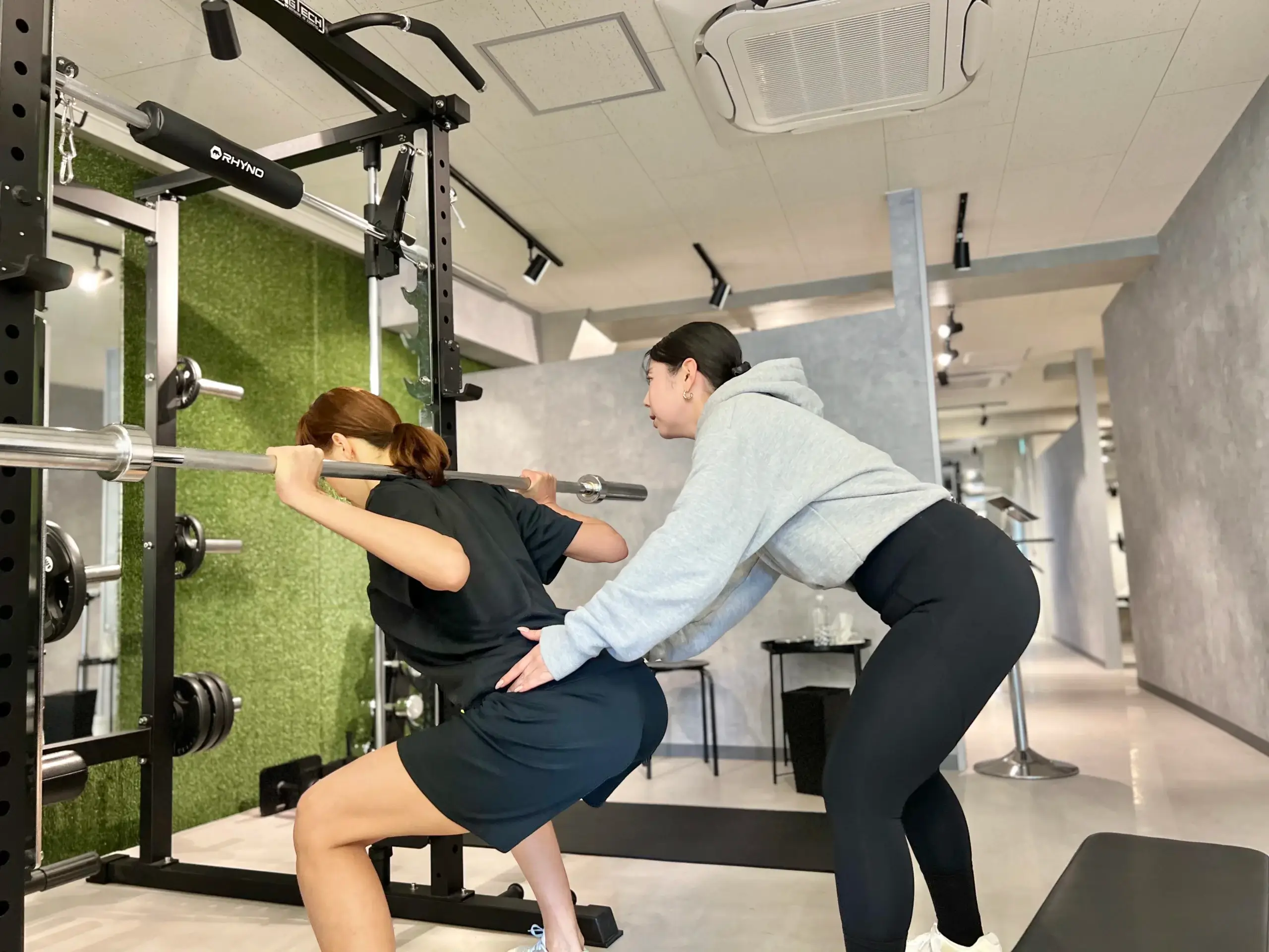 Kirei早稲田店で女性トレーナーにトレーニング指導を受けている日本人女性