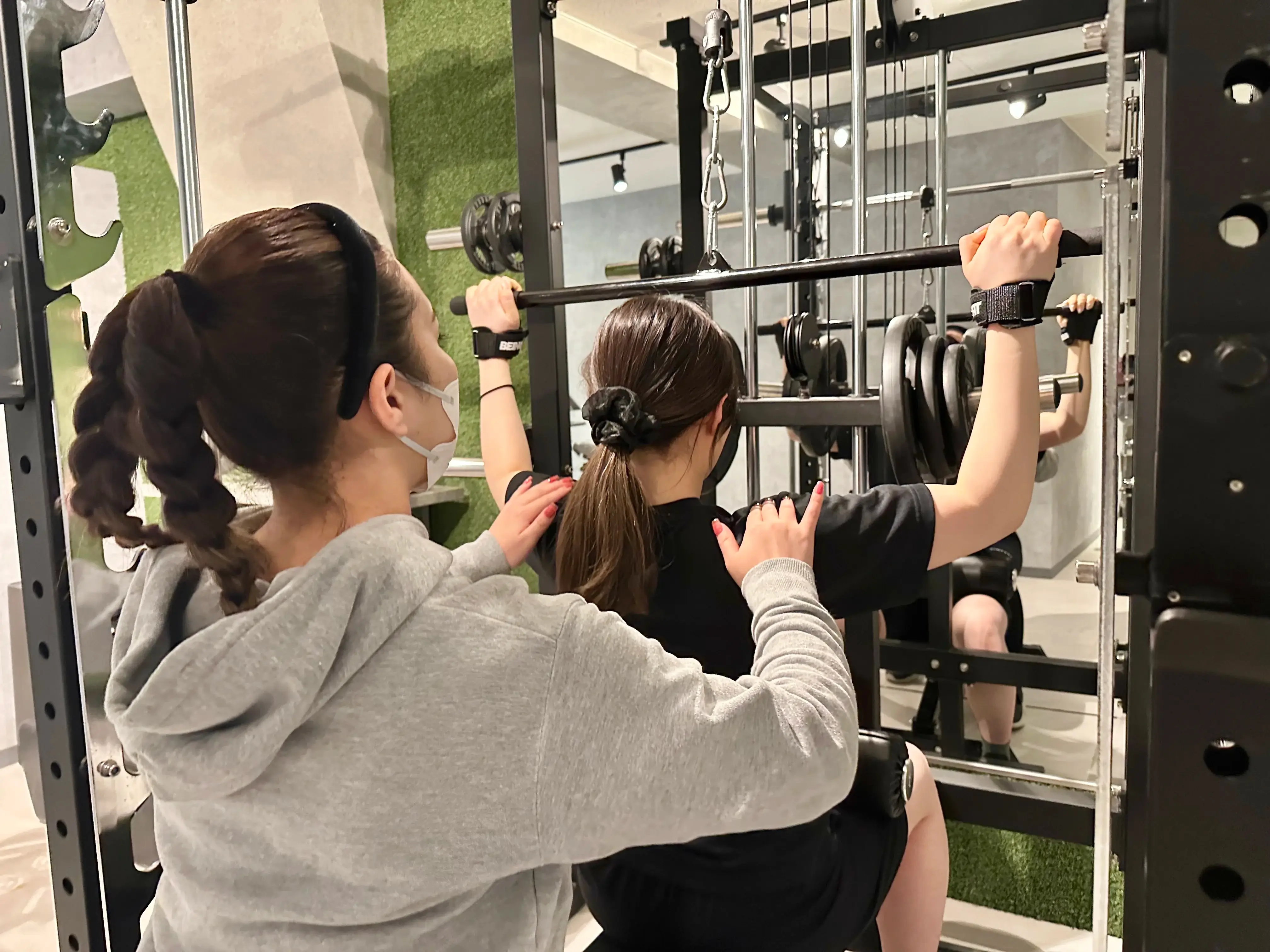 Kirei早稲田店で女性トレーナーにトレーニング指導を受けている日本人女性